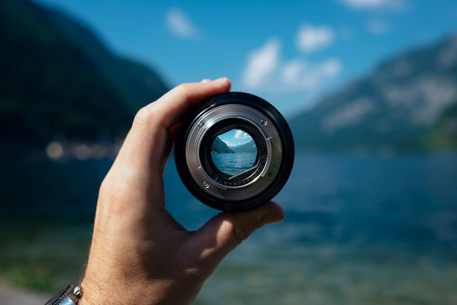 person holding up a lens and looking through the center